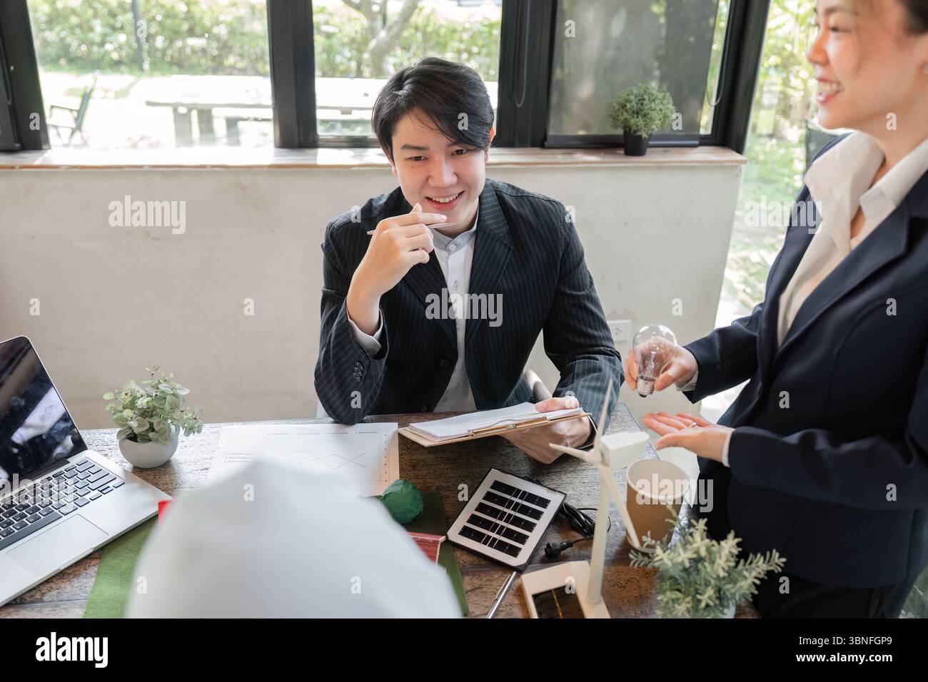 Nachhaltigkeit und innovative Lösungen. Gemeinsame Diskussionen über Projekte im Bereich erneuerbarer Energien in einem dynamischen Büro. Stockfoto
