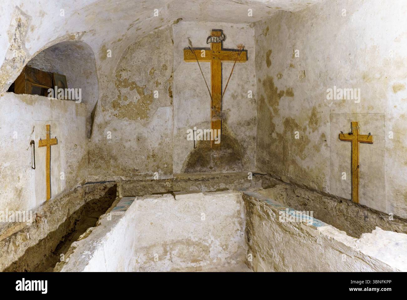 Ein feierlicher Blick auf eine alte unterirdische Krypta in der Kirche der Gesu (Casa Professa) in Palermo, Sizilien, mit einem rustikalen Steinaltar und einem W Stockfoto