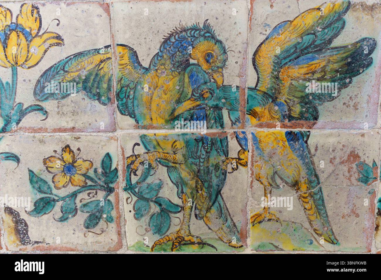 Ein detailliertes Fresko von zwei Vögeln mit blauen und gelben Federn, umgeben von gelben Blumen und grünen Blättern in der Kirche von Gesu (Chiesa Stockfoto