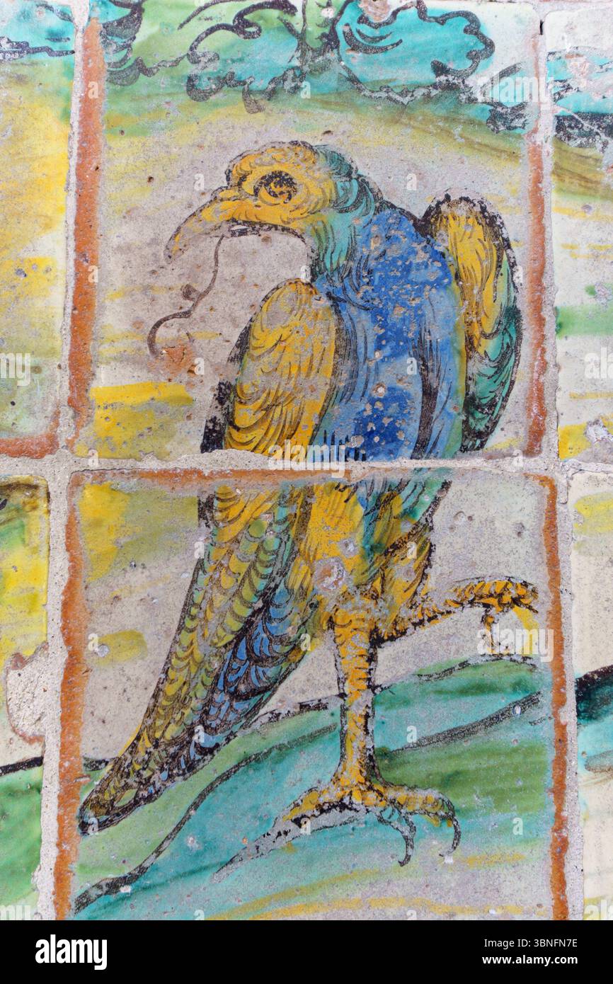 Ein lebhaftes Fresko eines Vogels mit gelbem und blauem Gefieder, das auf einem Bein inmitten grüner Blätter steht, befindet sich in der Kirche Gesù (Chiesa del Gesù) i. Stockfoto