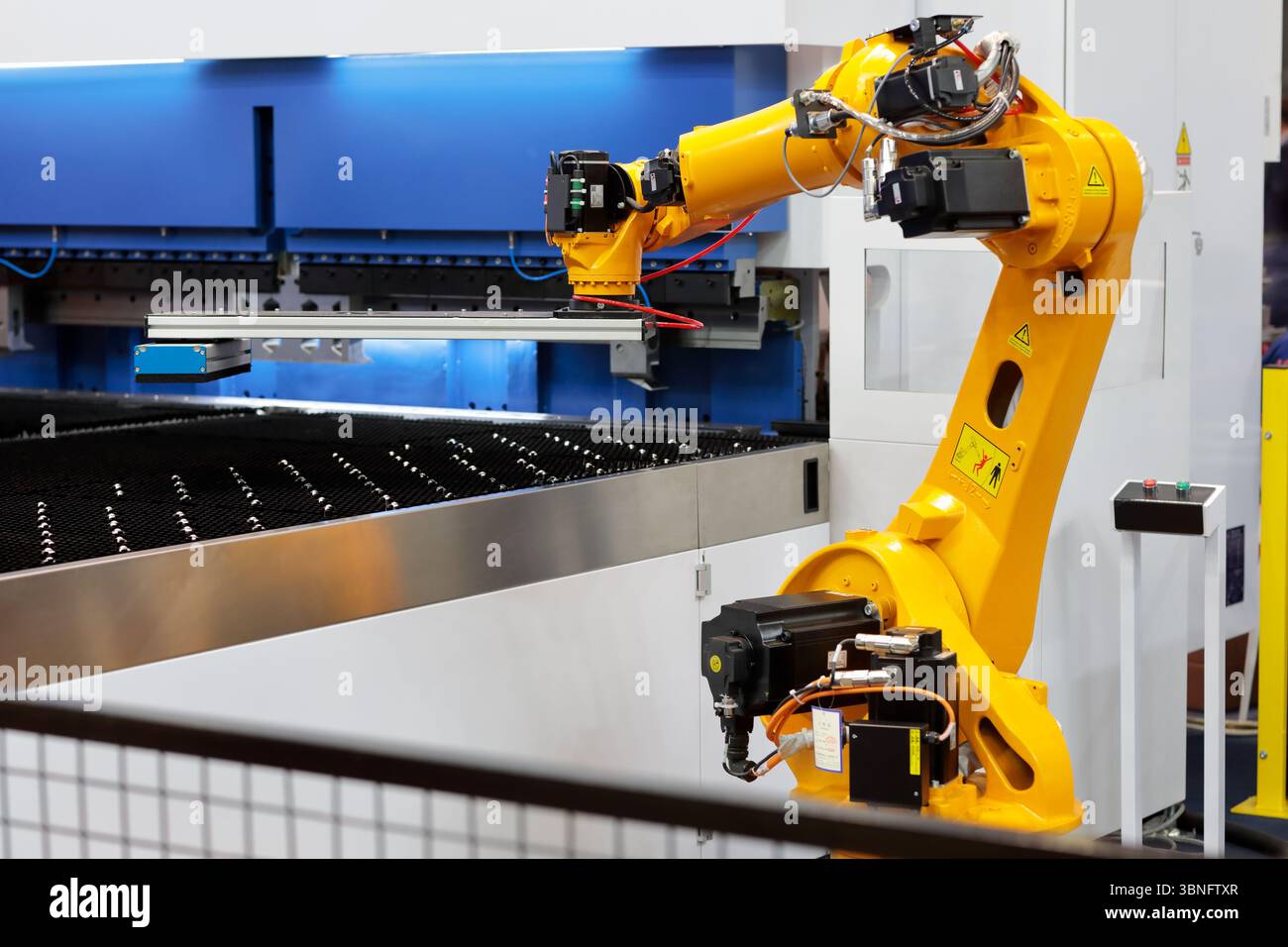 Automatisierungszelle für die Roboterpresse. Blechbiegemaschine und industrieller kollaborativer Roboter. Selektiver Fokus. Stockfoto