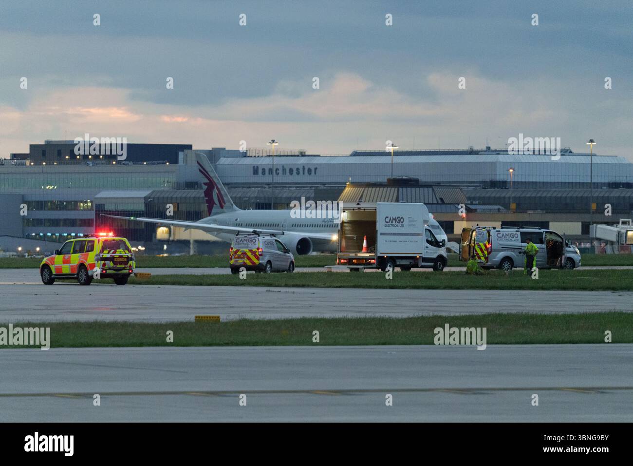 Nächtlicher Blick auf den Flughafen Manchester mit aktiven Notfall- und Servicefahrzeugen Stockfoto