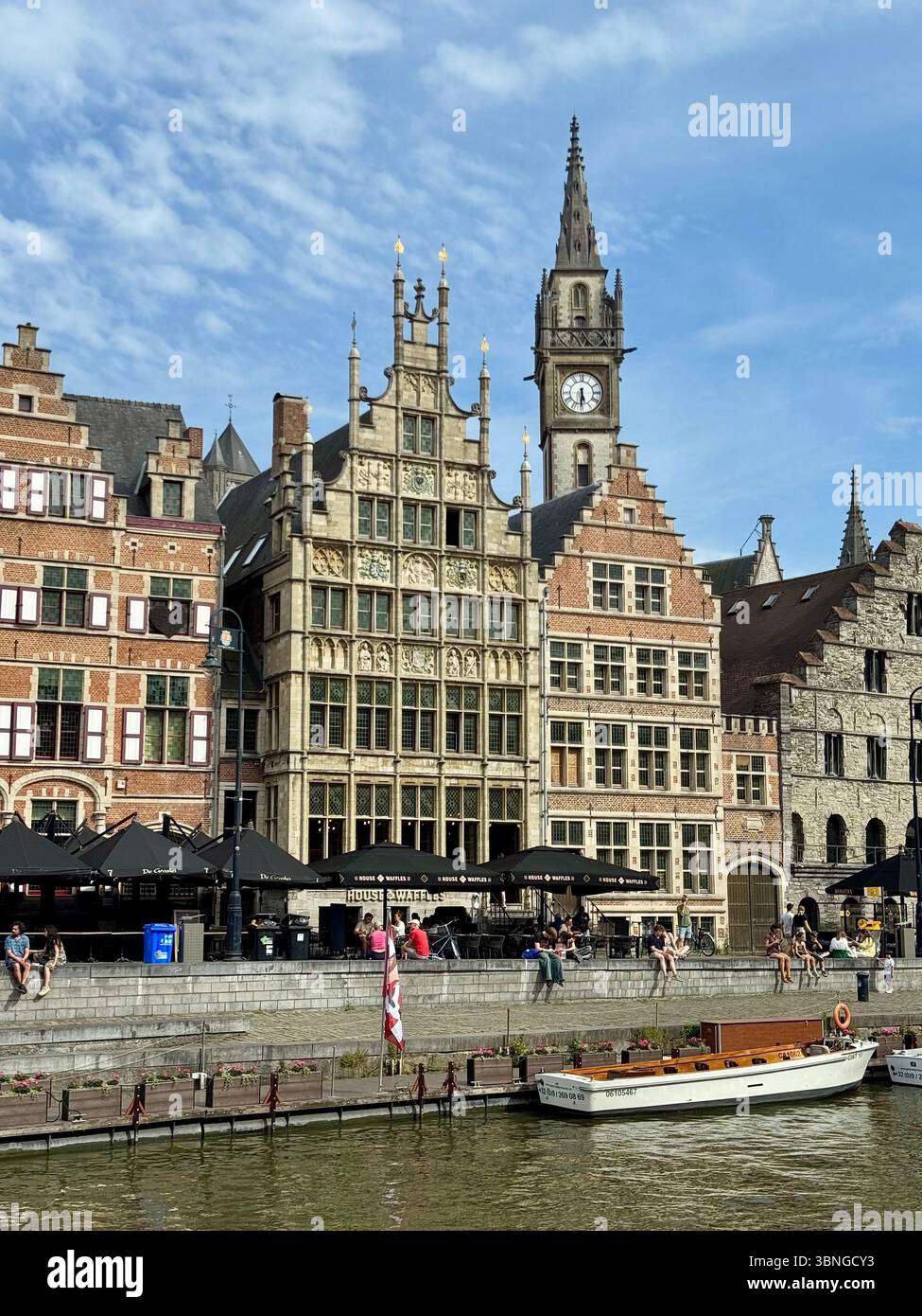 Historische Gildenhäuser und Uhrenturm entlang des Graslei-Kanals in Gent, Belgien. - Smartphone-aufgenommenes Stockfoto