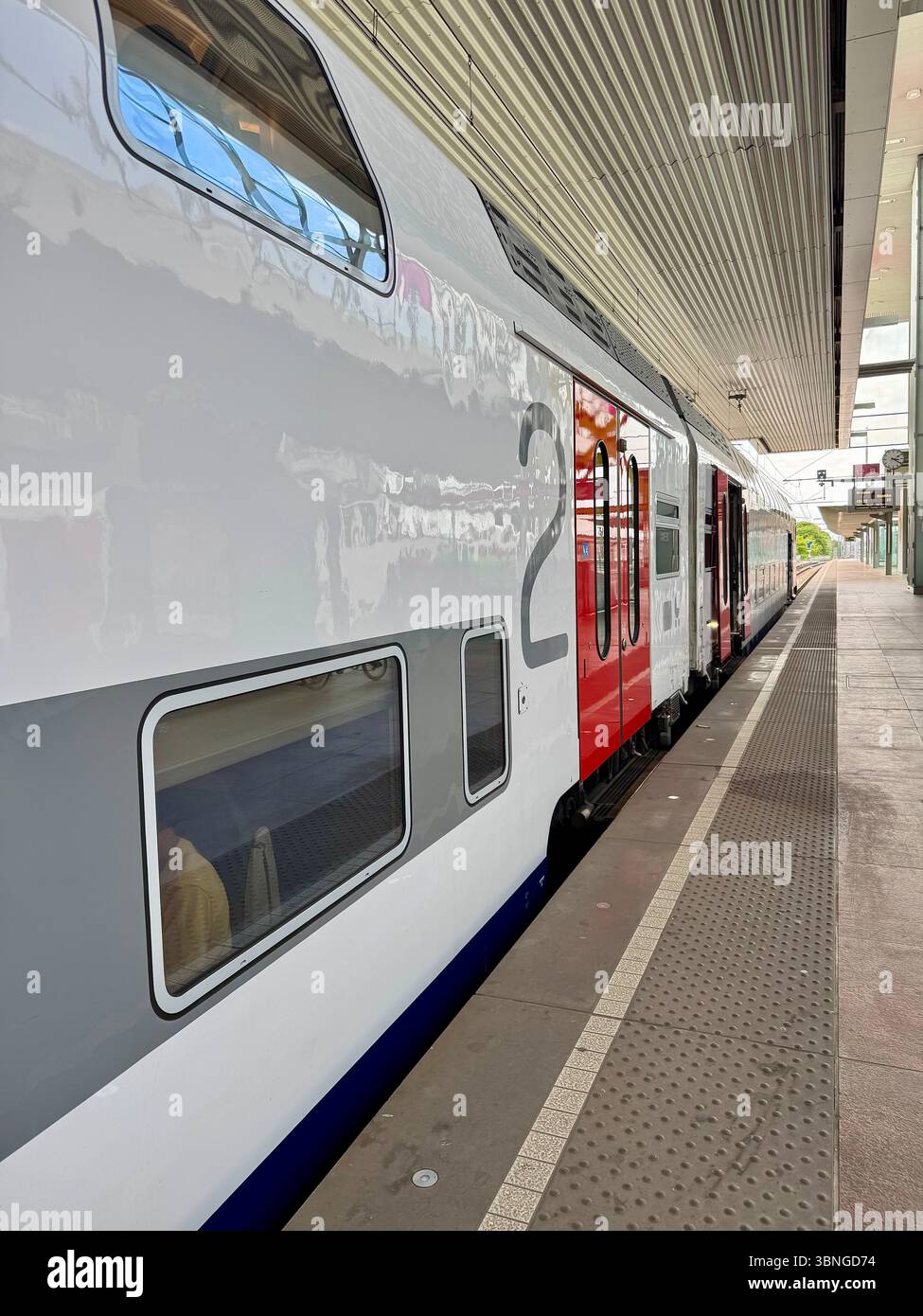 Doppeldeckerzug an einem belgischen Bahnsteig mit Außentüren und Eingangstüren. - Smartphone-aufgenommenes Stockfoto