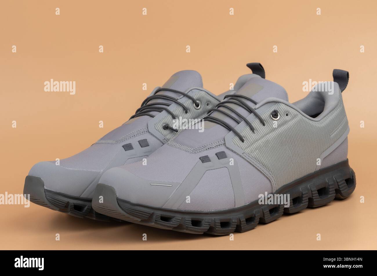 Leichte, graue Sportschuhe, ideal zum Laufen oder Training, mit modernem Design und bequemer Passform für den ganzen Tag. Stockfoto