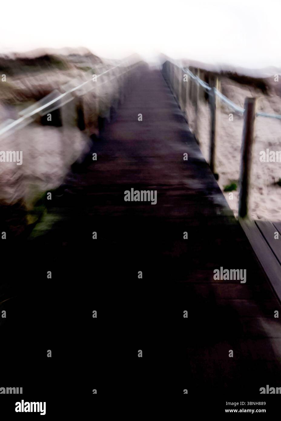 Ein abstraktes Bild einer Promenade, die zum Horizont führt, mit verschwommenen Details, die auf eine Küstenumgebung hinweisen. Stockfoto