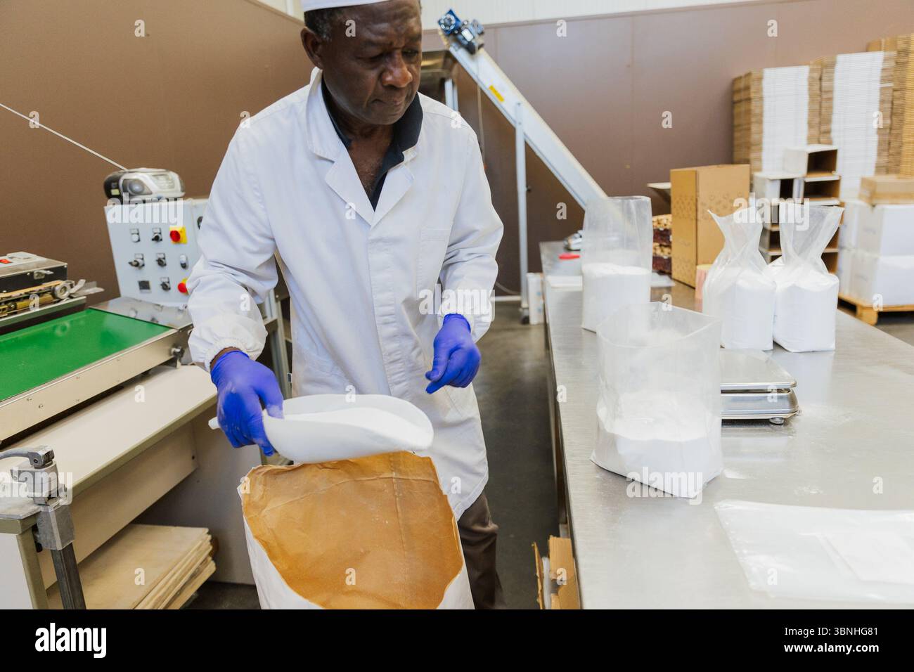Afrikanischer Lagerarbeiter, der Glucose bei der Arbeit verpackt. Stockfoto