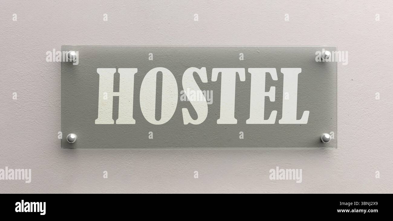 Das Glasschild DES HOSTELS ist an der weißen Wand verschraubt Stockfoto