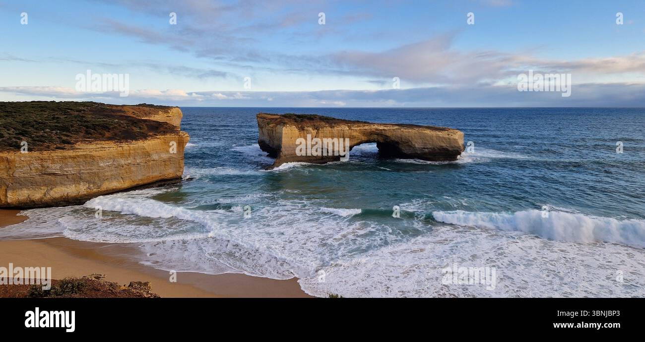Rock, Sea & Sand Australia. Eine markante Felsformation, die sich aus dem pulsierenden blauen Meer vor der Küste Australiens erhebt und von kristallklarem Wasser umgeben ist - Smartphone-aufgenommenes Stockfoto
