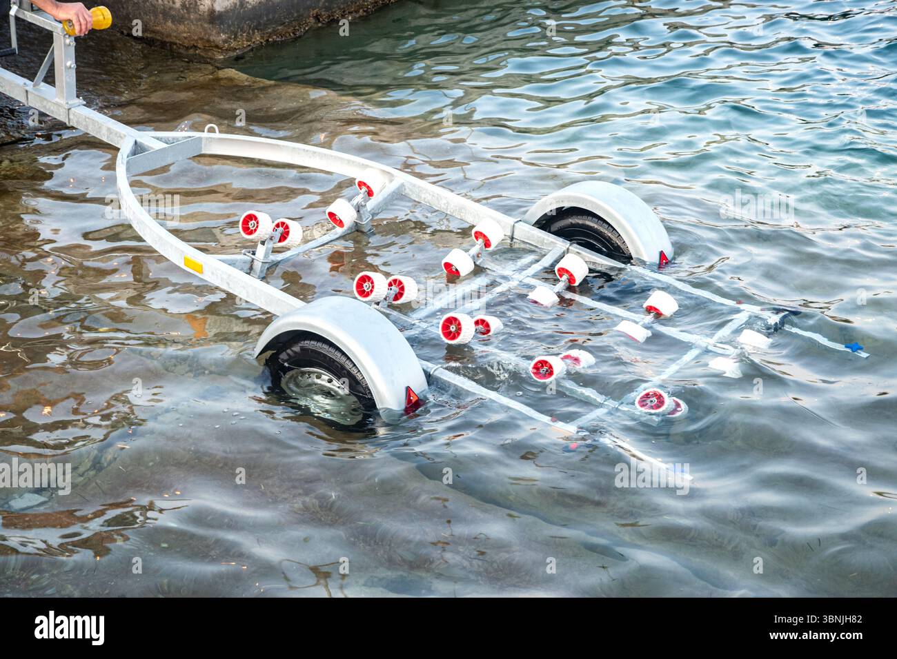 Bootsanhänger in Wasser getaucht, bereit für den Start oder das Auffinden eines Schiffes Stockfoto