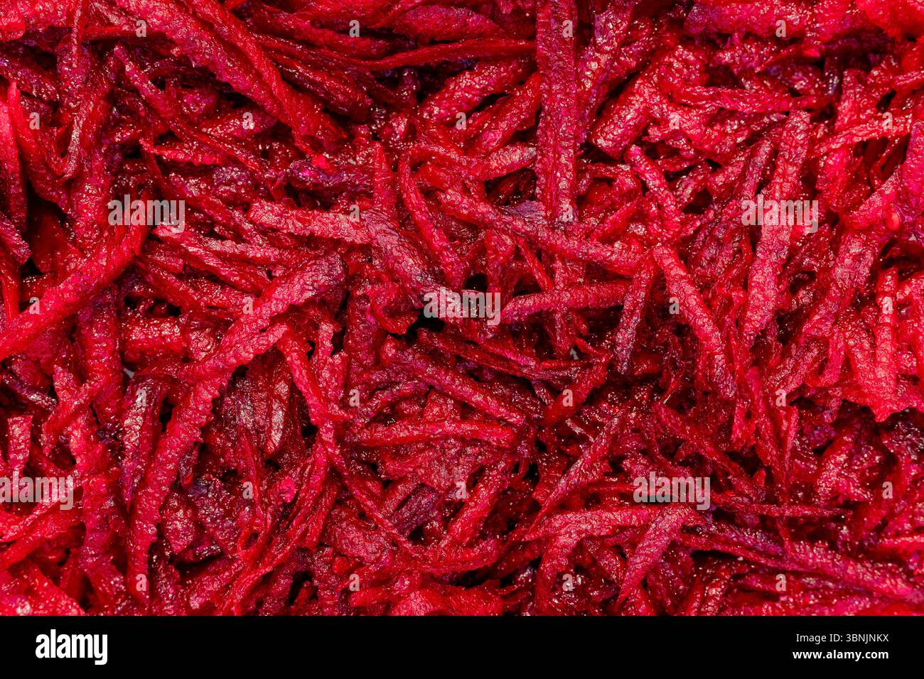 Ein Nahaufnahme-Bild, das die lebendige Textur von Rote Bete-Streifen zeigt, perfekt für Hintergründe. Die komplizierten Details betonen die natürliche Farbe und die natürliche Farbe Stockfoto