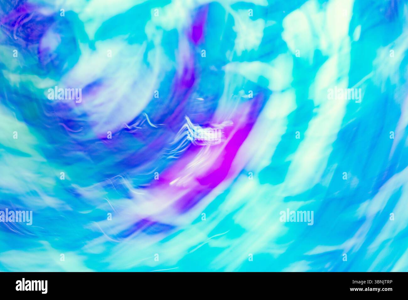 Ein dynamisches, abstraktes Bild mit wirbelnden Blau-, Violett- und Weißtönen, das die Essenz der Chromadynamik einfängt. Die pulsierenden Wellen erzeugen ein Mesmeri Stockfoto