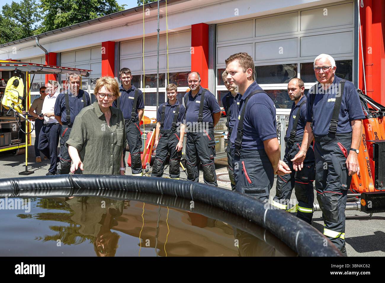 Vorstellung neuer technischer Einsatzmittel des Katastrophenschutzes Niedersachsen bei Außentemperaturen von 38 Grad Celsius Vegetationsbrandbekämpfung: 5000 Liter Löschwasserbehälter, Präsentation durch die Feuerwehr Westerloy Landkreis Ammerland, Wechselladerfahrzeug WLF 32 und Abrollbehälter Vegetationsbrandbekämpfung ab-VEG mit Feuerwehrleuten, Daniela Behrens, Niedsersächsische Innenministerin schaut sich die Technik an. Hannover Deutsches Rotes Kreuz DRK, SIM Niedersachsen, Region Hannover Deutschland *** Präsentation neuer technischer Ressourcen des Katastrophenschutzes Niedersachsens bei Outs Stockfoto