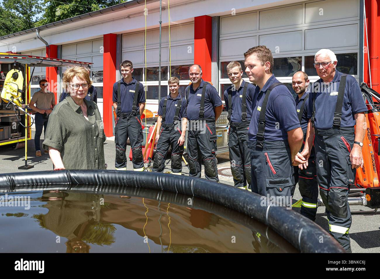 Vorstellung neuer technischer Einsatzmittel des Katastrophenschutzes Niedersachsen bei Außentemperaturen von 38 Grad Celsius Vegetationsbrandbekämpfung: 5000 Liter Löschwasserbehälter, Präsentation durch die Feuerwehr Westerloy Landkreis Ammerland, Wechselladerfahrzeug WLF 32 und Abrollbehälter Vegetationsbrandbekämpfung ab-VEG mit Feuerwehrleuten, Daniela Behrens, Niedsersächsische Innenministerin schaut sich die Technik an. Hannover Deutsches Rotes Kreuz DRK, SIM Niedersachsen, Region Hannover Deutschland *** Präsentation neuer technischer Ressourcen des Katastrophenschutzes Niedersachsens bei Outs Stockfoto