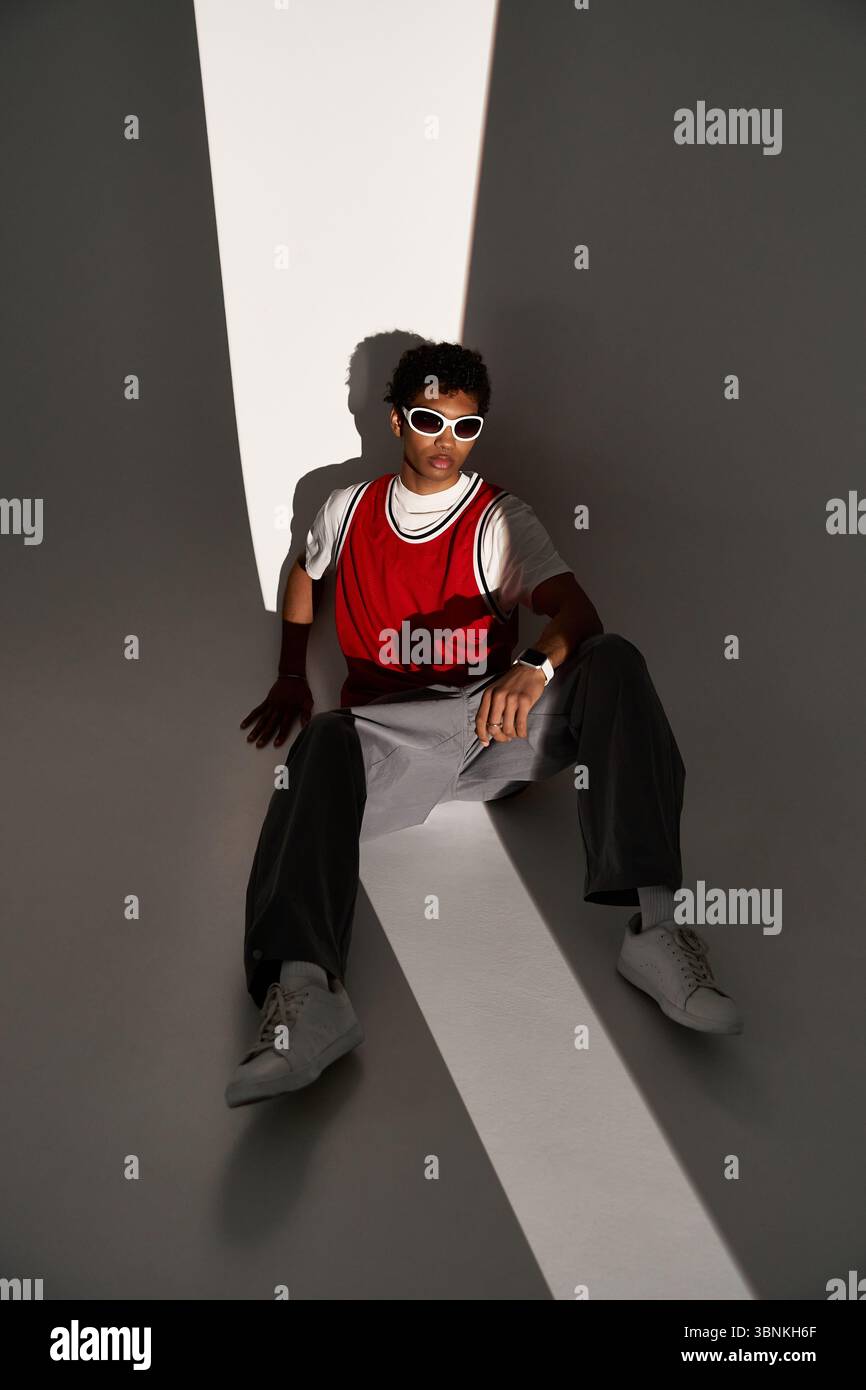 Zwei junge Liebhaber teilen sich einen gemütlichen und stilvollen Moment, umgeben von künstlerischen Schatten und Licht. Stockfoto