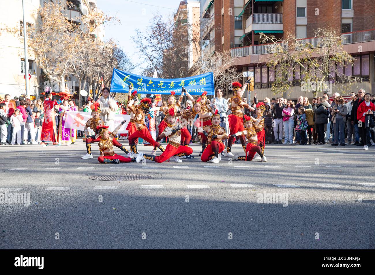 Junge chinesische Künstler tanzen in roten Nationalkostümen. Die Chinesen feiern das chinesische Neujahr in Spanien, Barcelona 01.25.2025 Stockfoto