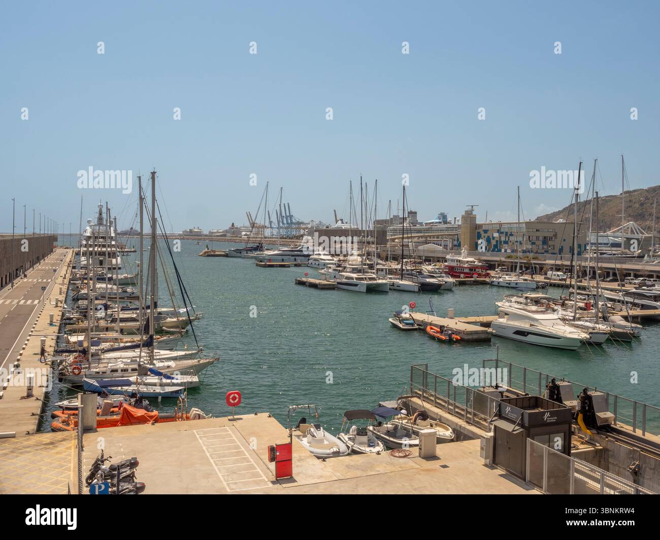 Blick aus der Höhe auf den weitläufigen Hafen von Barcelona, mit Docks voller Freizeitboote und der wichtigsten Mole in der Ferne. Spanien Stockfoto