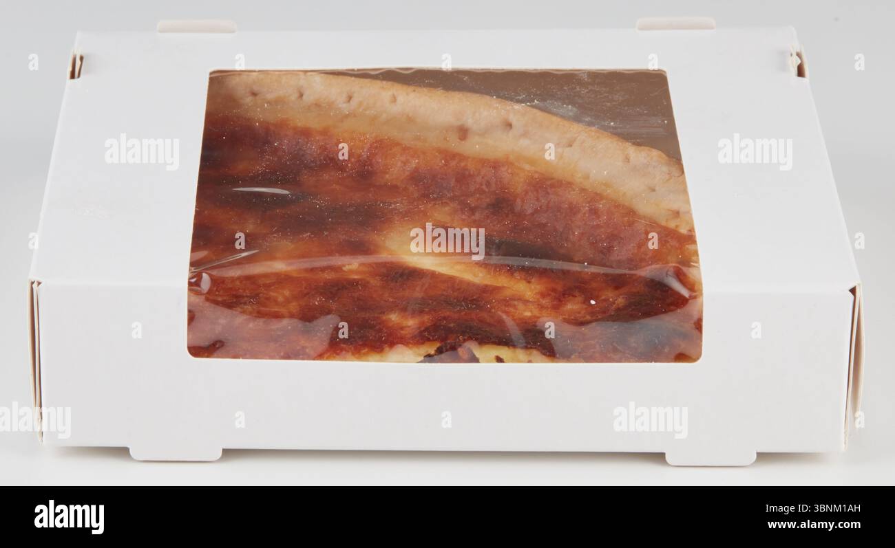 Eine dreieckige Pizzascheibe hatte verbrannte Flecken im Karton. Stockfoto