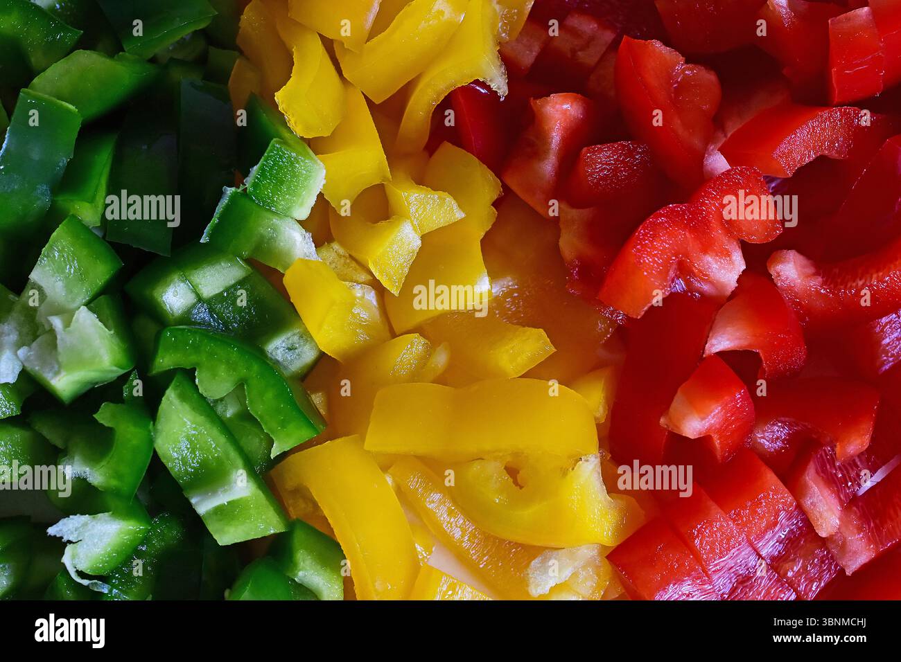 Grüne, gelbe und rote Paprika in Stücke geschnitten Stockfoto