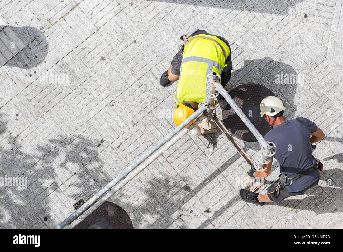 Draufsicht zweier Arbeiter in Arbeitsschutzkleidung, die Gerüstbauweise montieren Stockfoto
