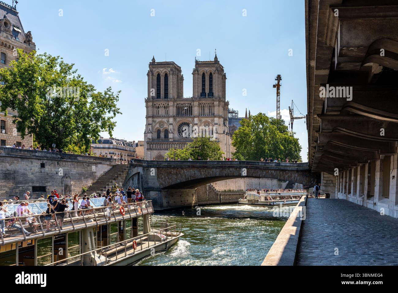 Touristen Boote auf der seine mit im Hintergrund der Kathedrale Notre Dame an einem sonnigen Sommertag. Stockfoto