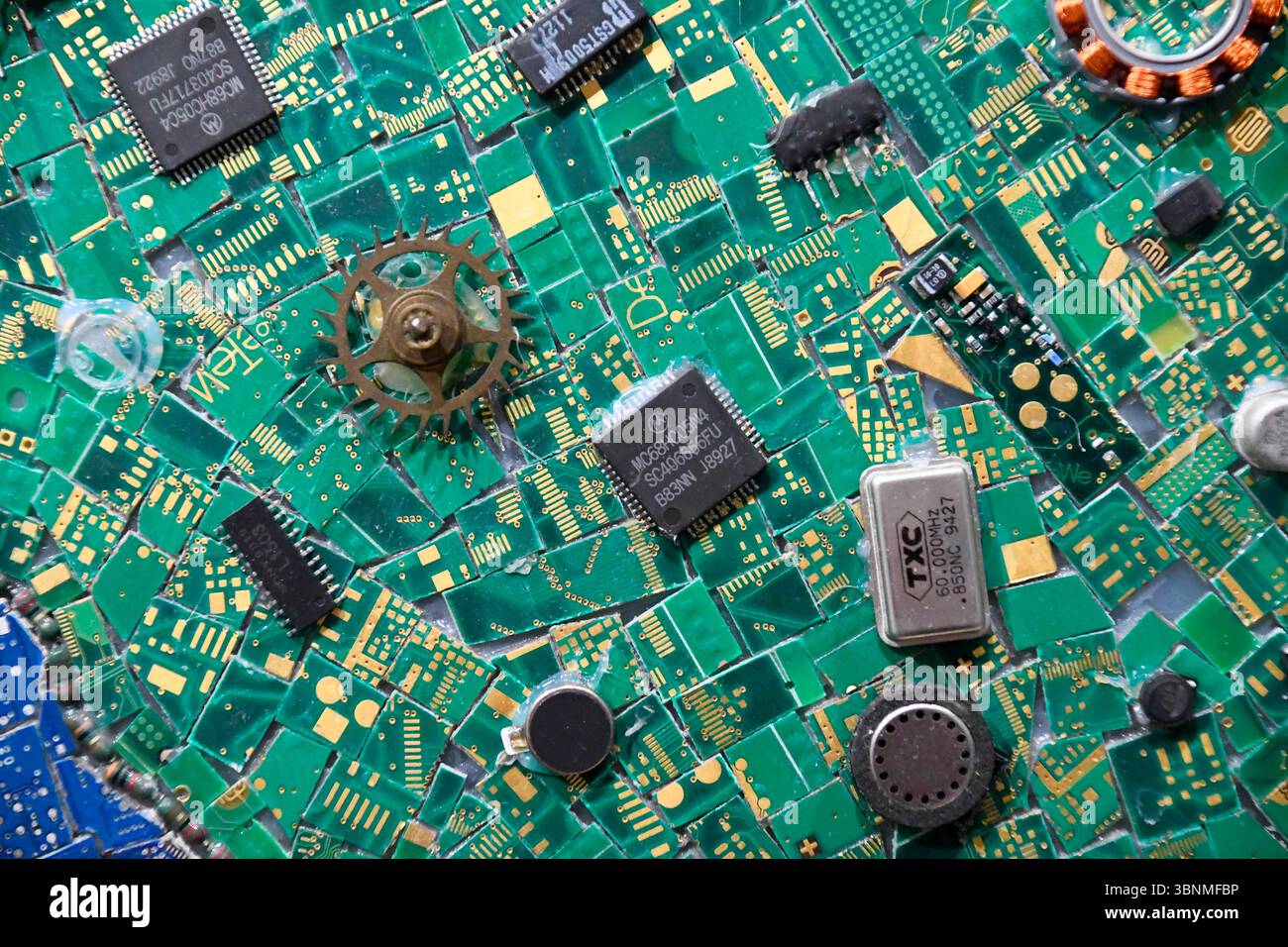 Mosaik aus bestückten Teilen von Computerplatinen mit verschiedenen elektronischen Komponenten Stockfoto