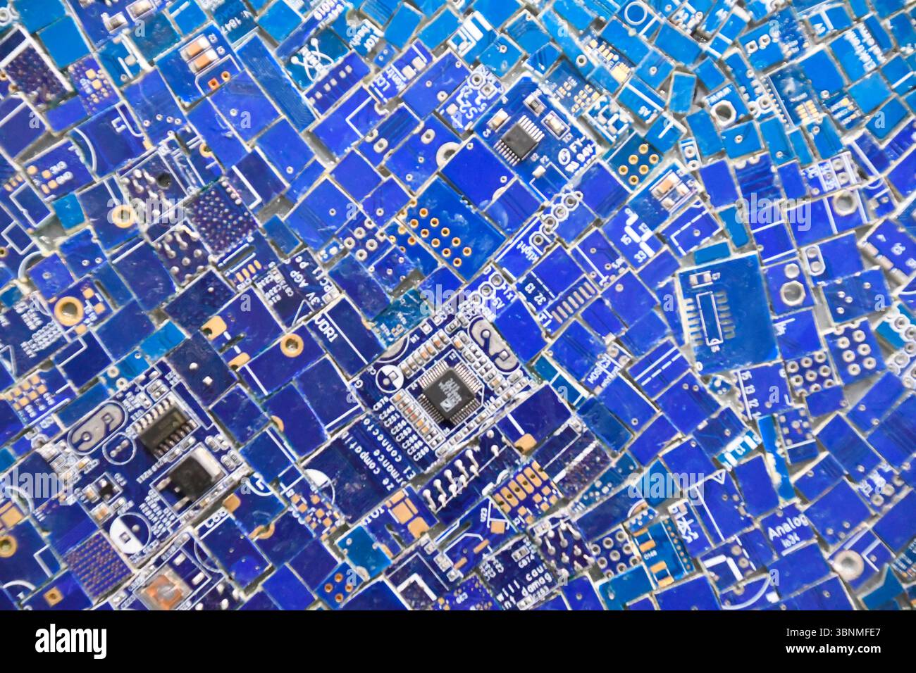 Mosaik aus bestückten Teilen von Computerplatinen mit verschiedenen elektronischen Komponenten Stockfoto