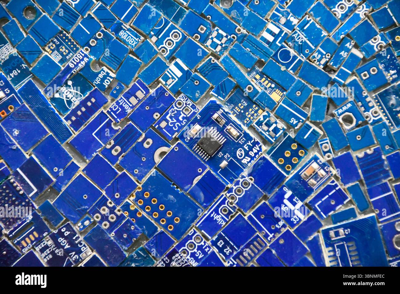 Mosaik aus bestückten Teilen von Computerplatinen mit verschiedenen elektronischen Komponenten Stockfoto