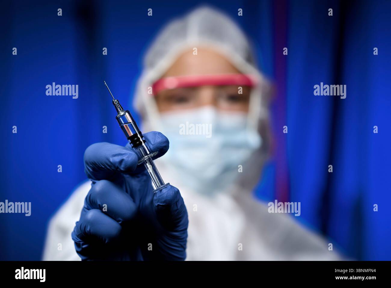 Medical staff with protective suit and syringe Stockfoto