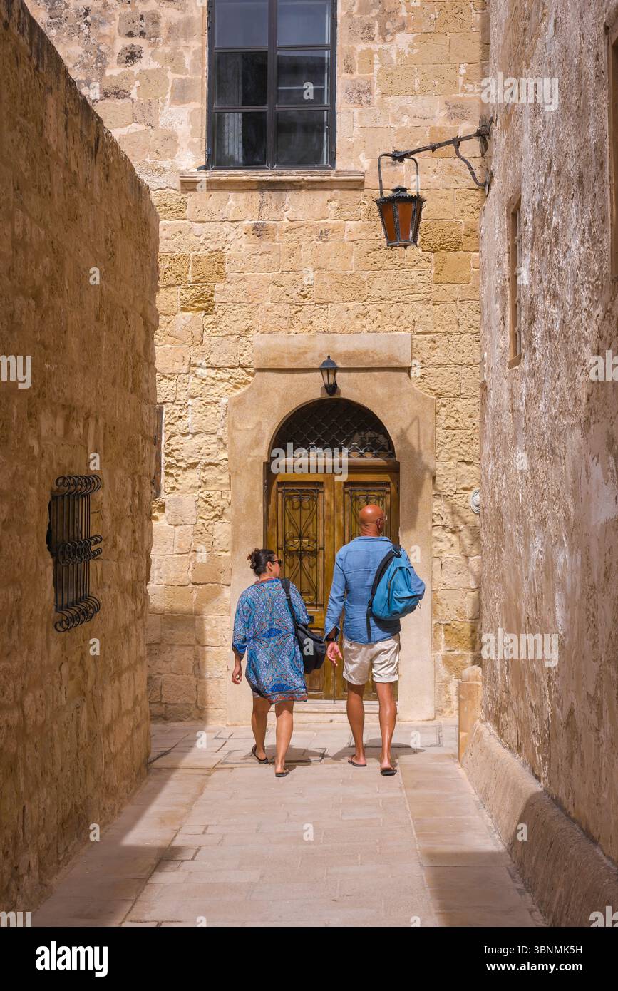 Urlaub für ältere Ehepaare, Rückansicht eines Touristenpaares, das die malerischen engen Gassen der historischen Mdina ummauerten Stadt in der Nähe von Rabat, Malta, erkundet Stockfoto