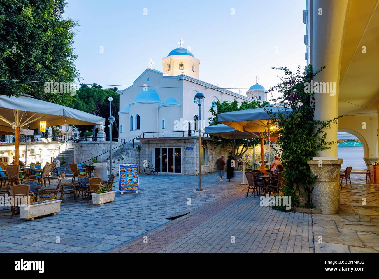 Platia Agias Paraskevis mit Blick auf die Kirche Agia Paraskevi und Arkade der Markthalle am Abend in Kos Stadt auf der Insel Kos in Griechenland Stockfoto