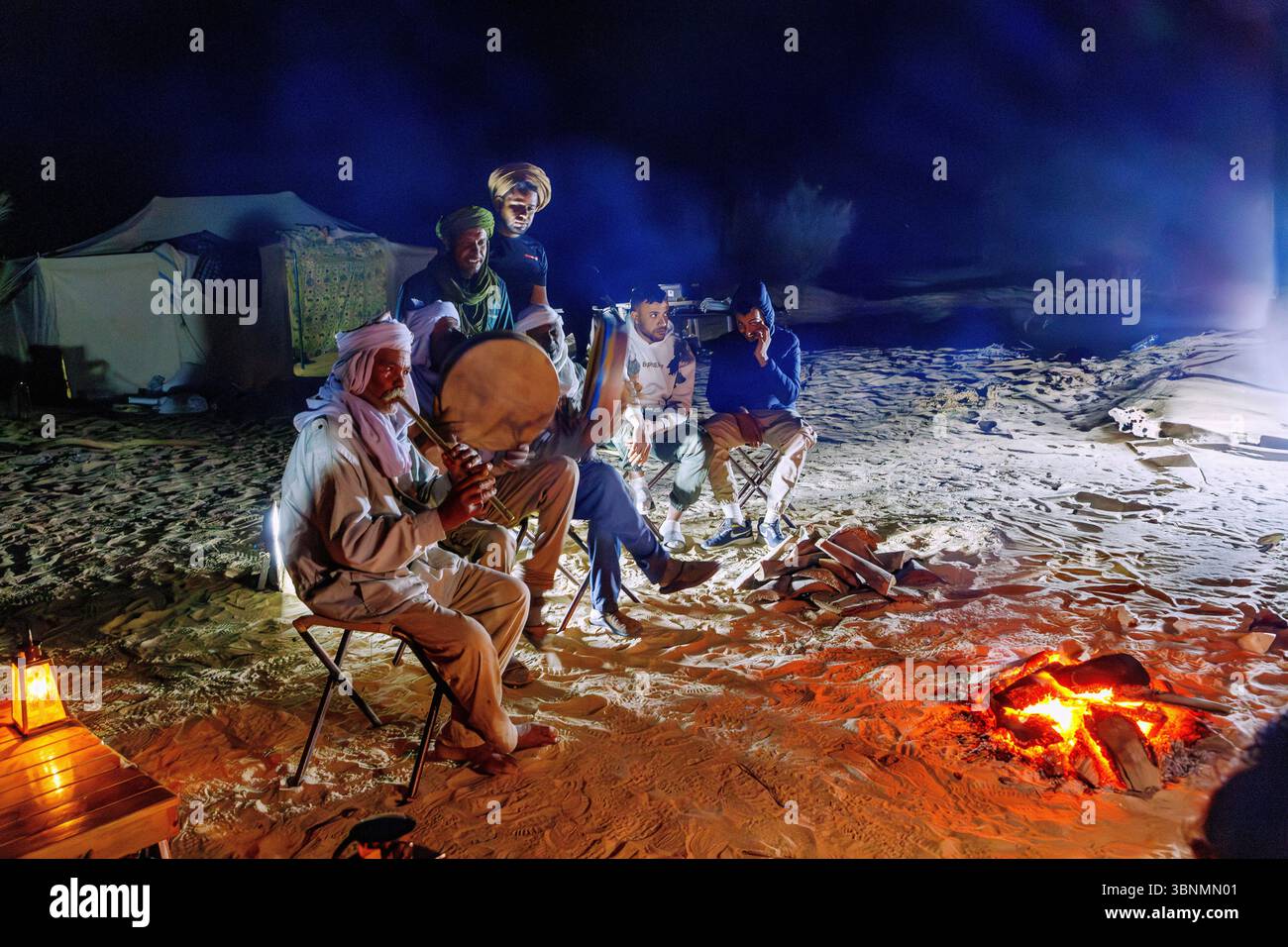 Nomaden musizieren an einem Lagerfeuer in einem Wüstencamp in der Sahara bei Douz, Tunesien Stockfoto