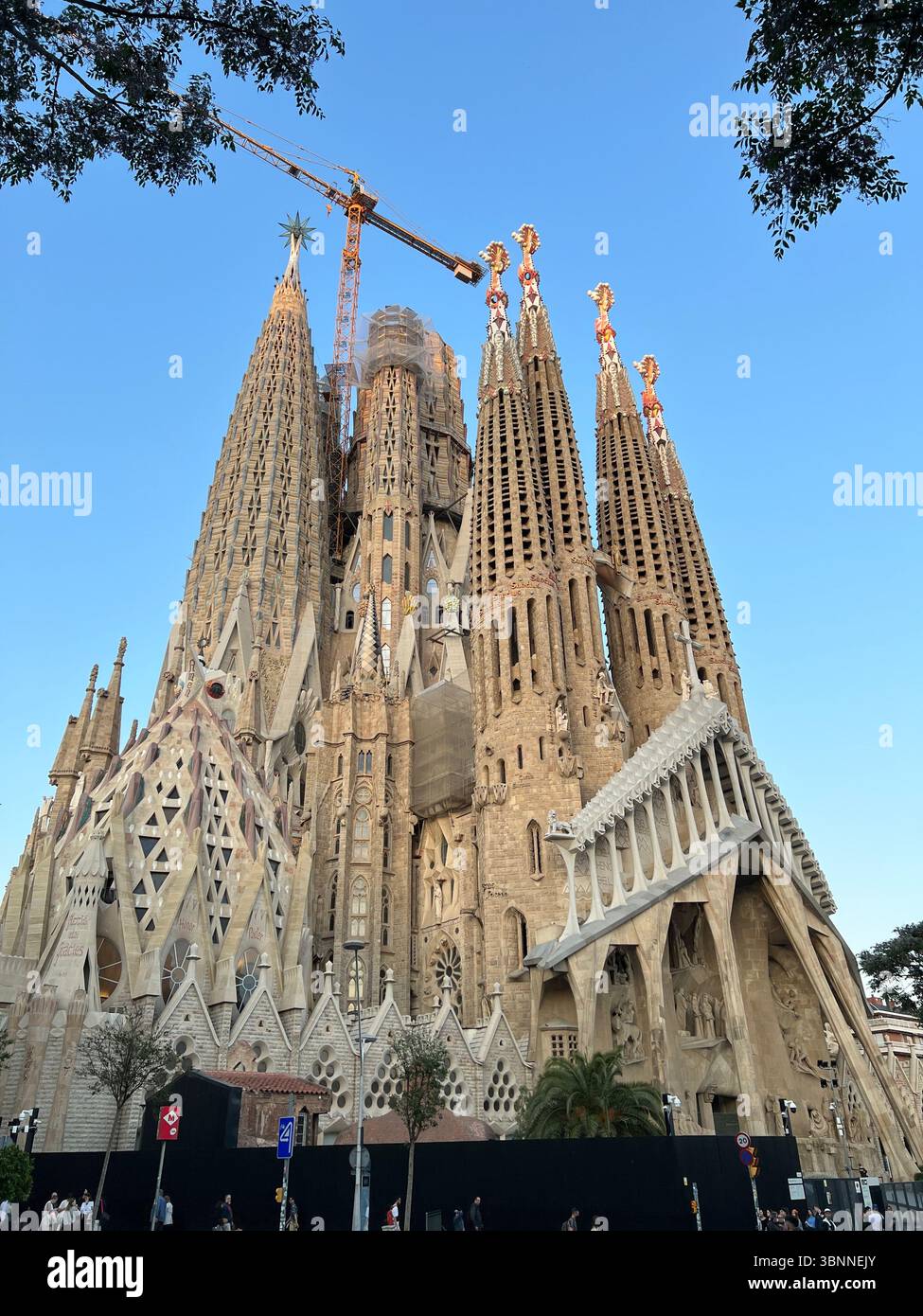 Die Sagrada Familia in Barcelona zeigt ihre atemberaubende gotische Architektur vor einem blauen Himmel. - Smartphone-aufgenommenes Stockfoto