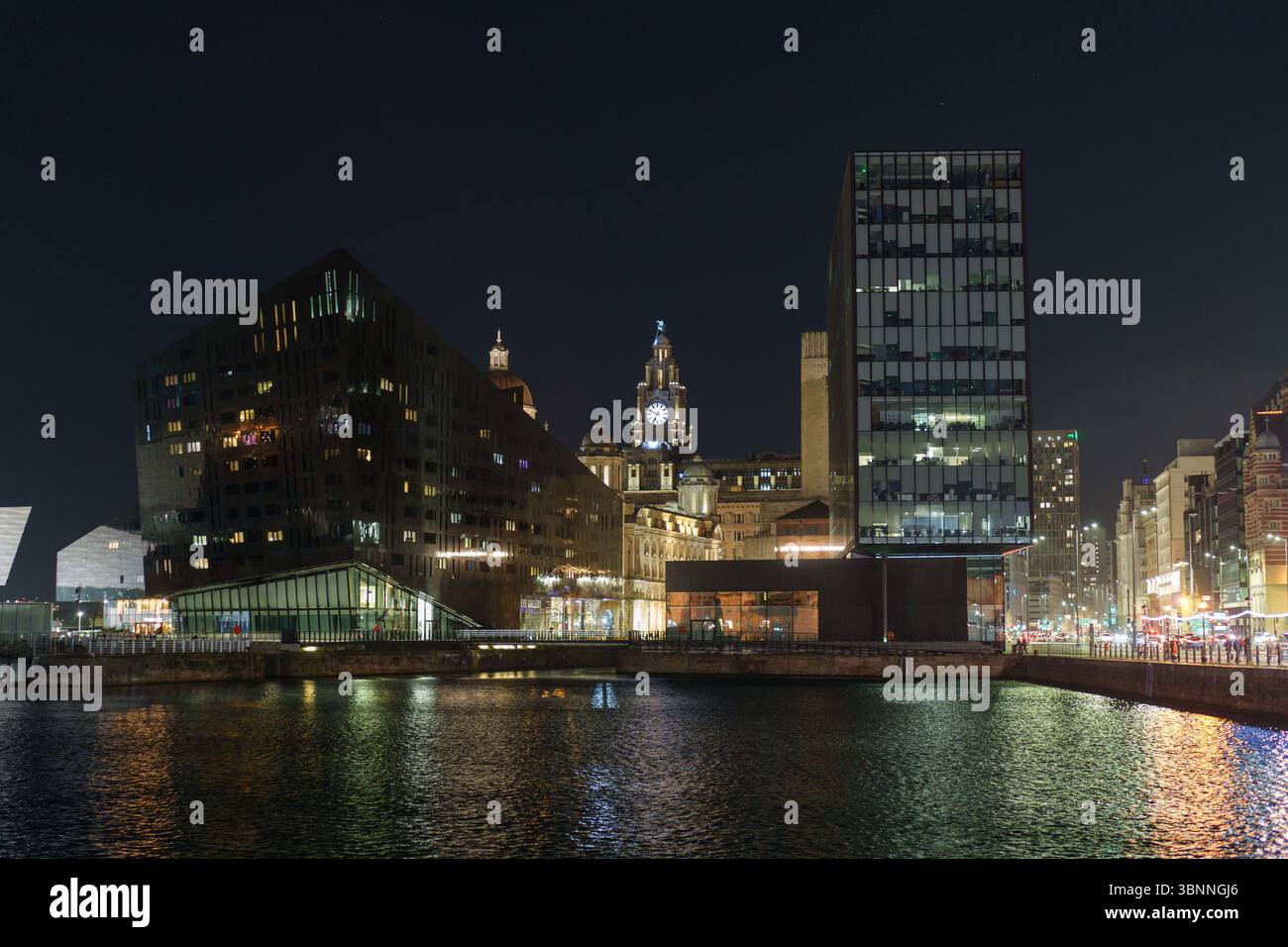 Die Skyline von Liverpool spiegelt sich nachts im Canning Dock Stockfoto