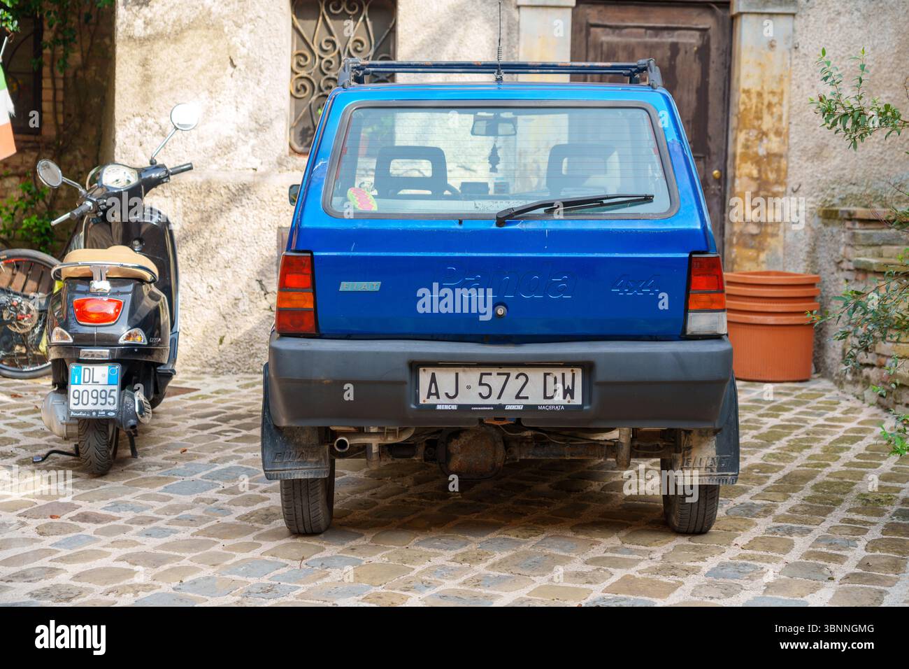 Alte blaue Fiat Panda 4x4 auf einer Kopfsteinpflasterstraße im Dorf Sarnano Stockfoto