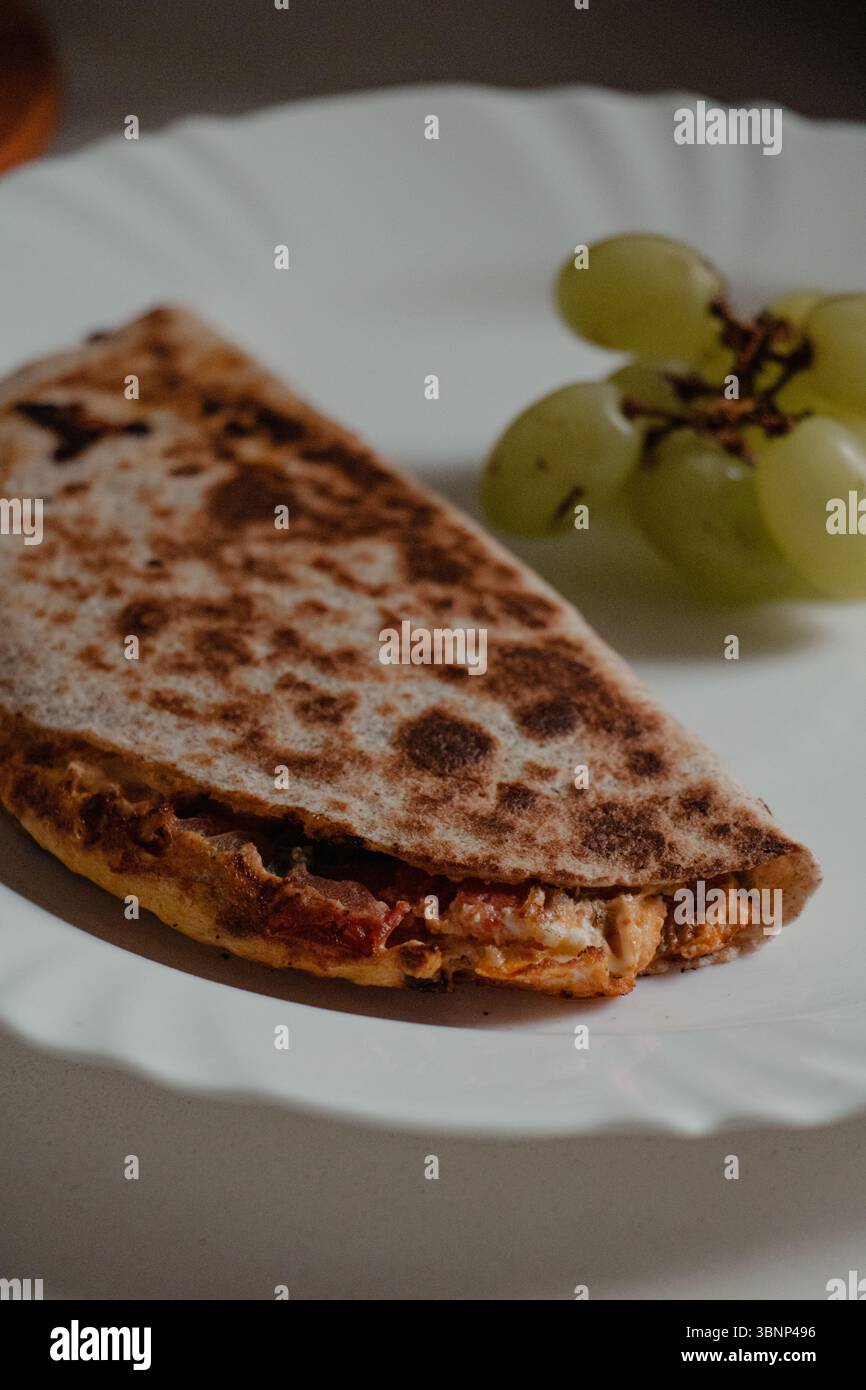 Nahaufnahme von Quesadilla mit Trauben auf Teller Stockfoto