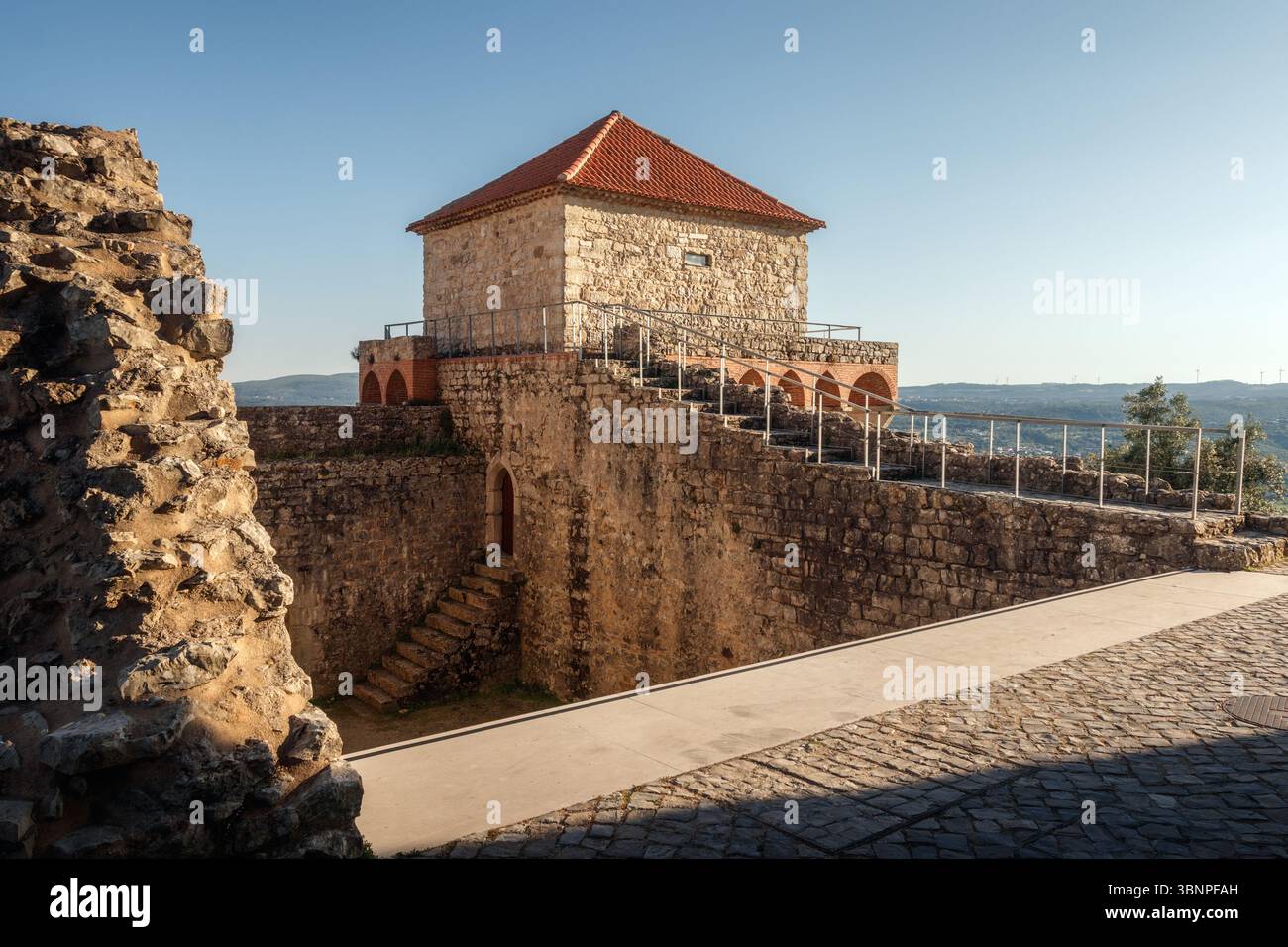 Blick auf die Rückseite eines der Bastionstürme der Burg von Ourém in Portugal mit dem blauen Himmel im Hintergrund. Stockfoto