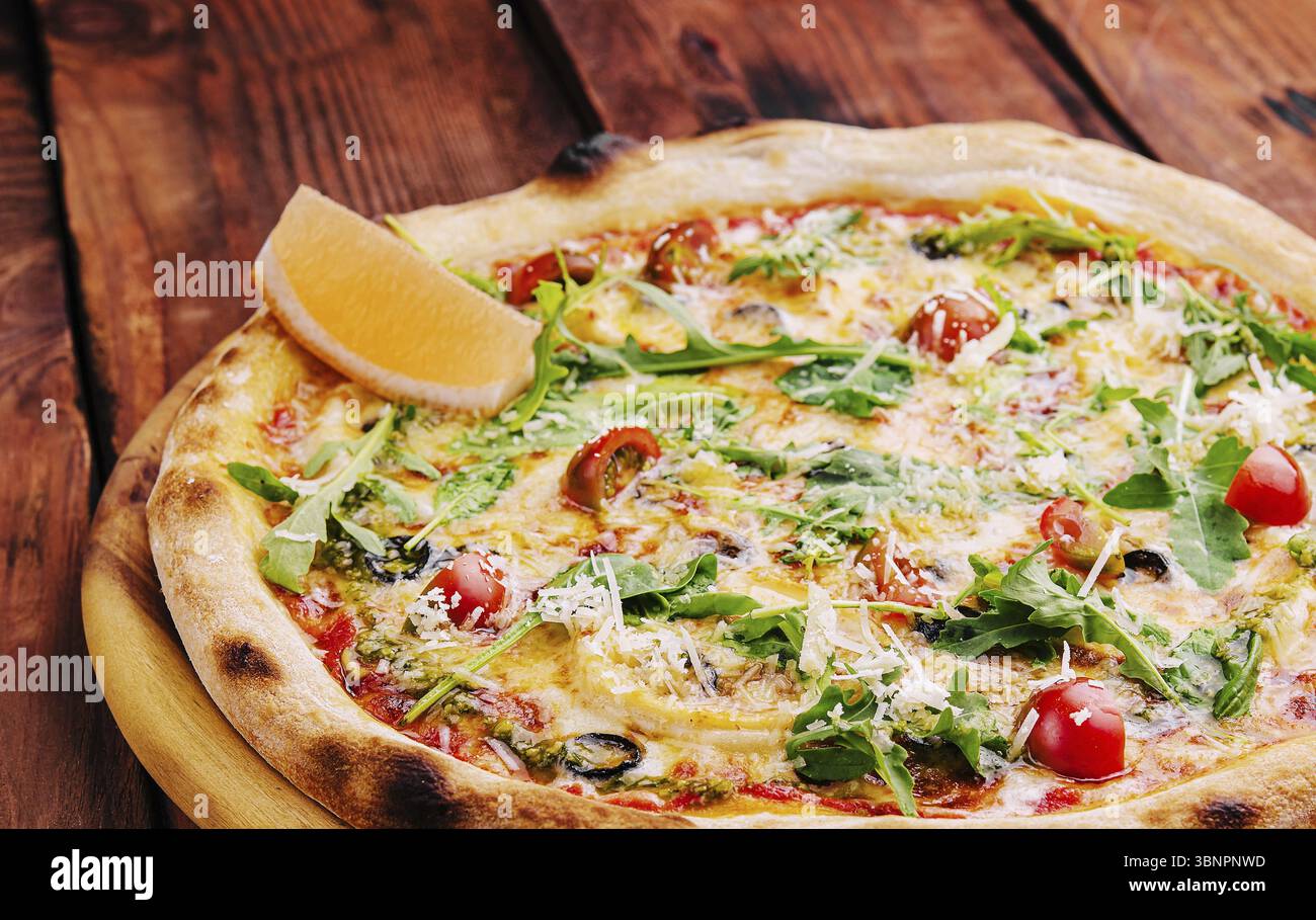 Essen Stillleben, Pizza mit Rucola, Käse, Joghurt und Kirschtomaten aus der Nähe Stockfoto