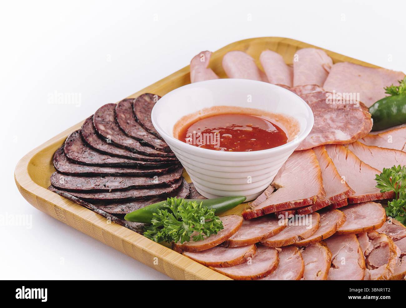 Stillleben, verschiedene Feinkost-Wurstwaren auf Holztablett Stockfoto
