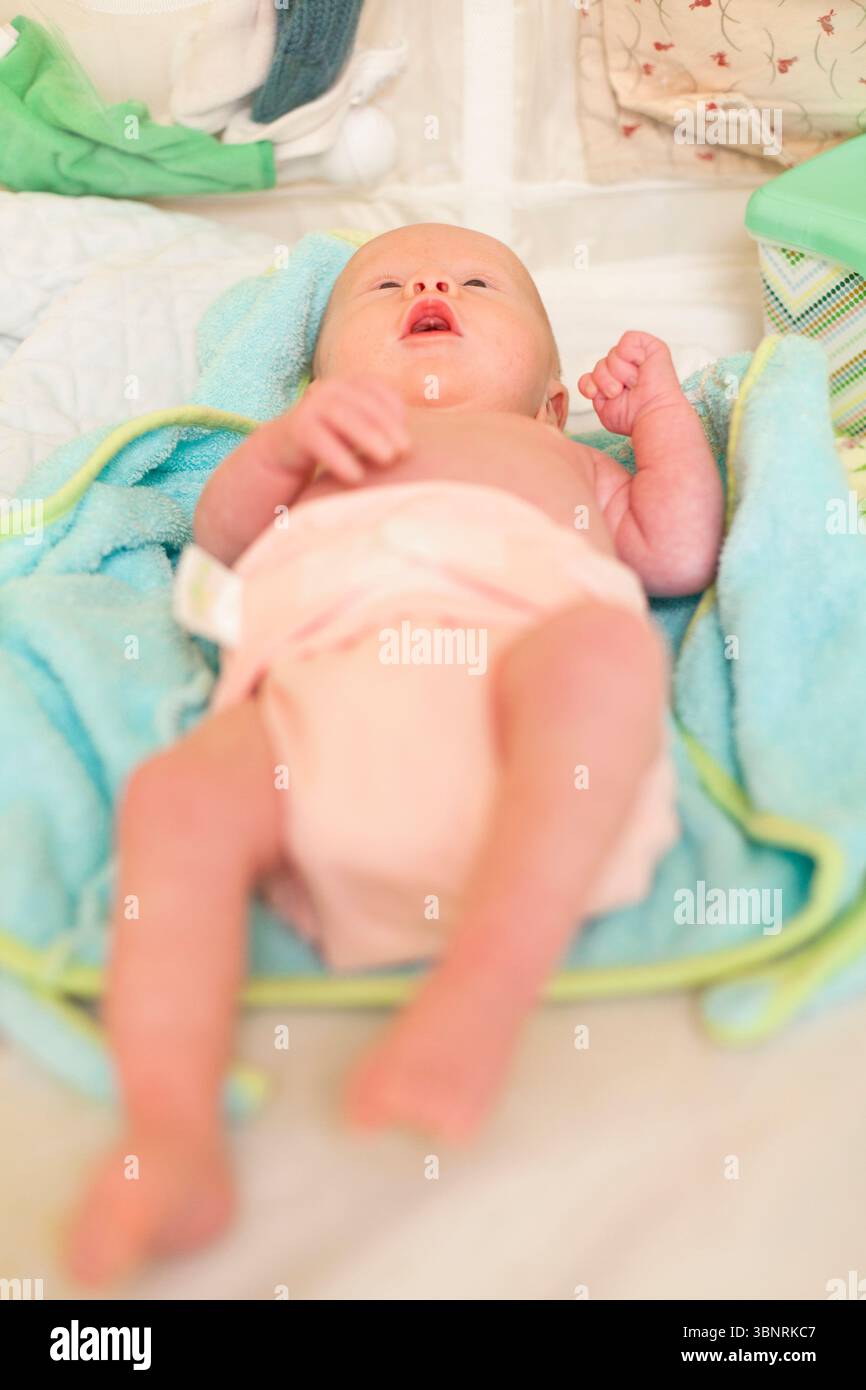 Ein neugeborenes Baby in einer rosafarbenen Windel liegt auf dem Wickeltisch. Stockfoto