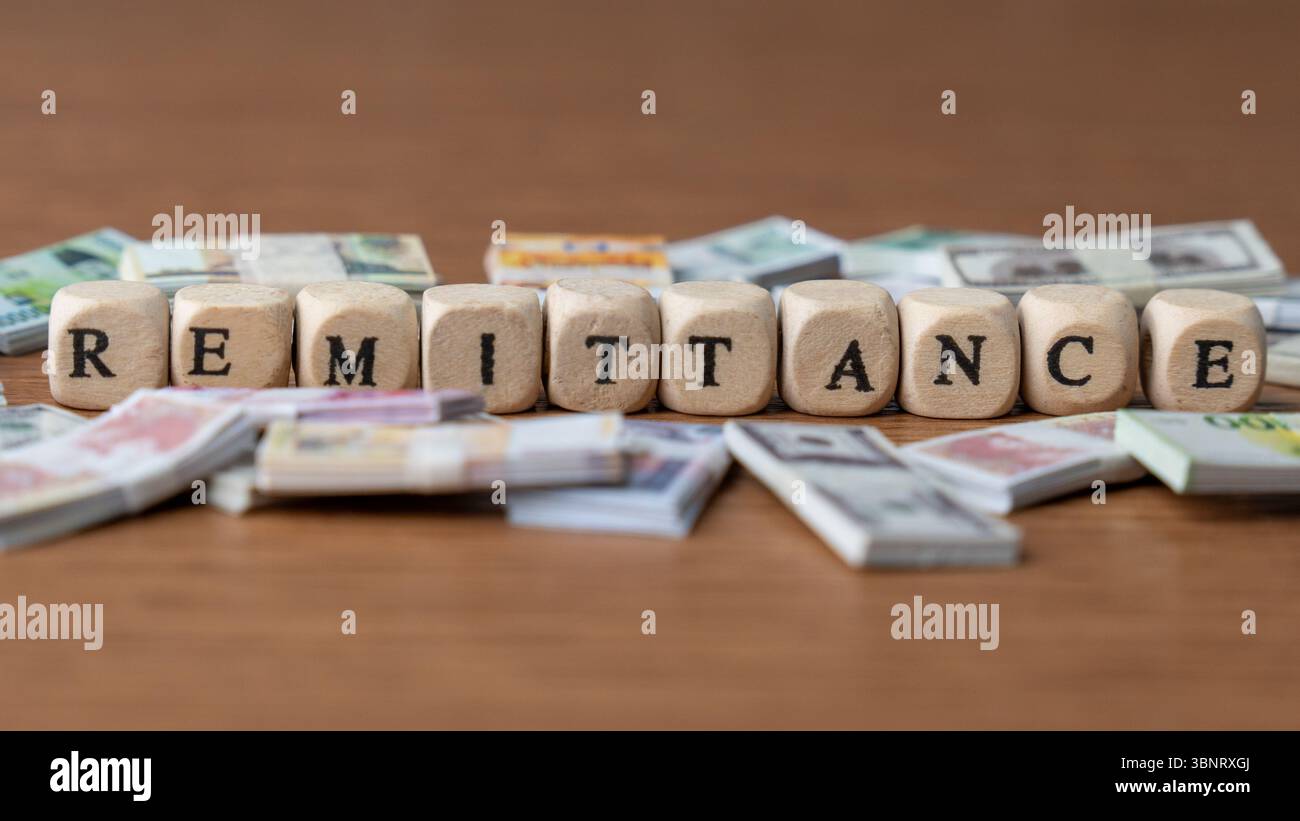 Das Wort "ÜBERWEISUNG", umgeben von Banknoten aus verschiedenen Ländern. Überweisungen, globale Geldtransfers, internationale Finanzen Stockfoto