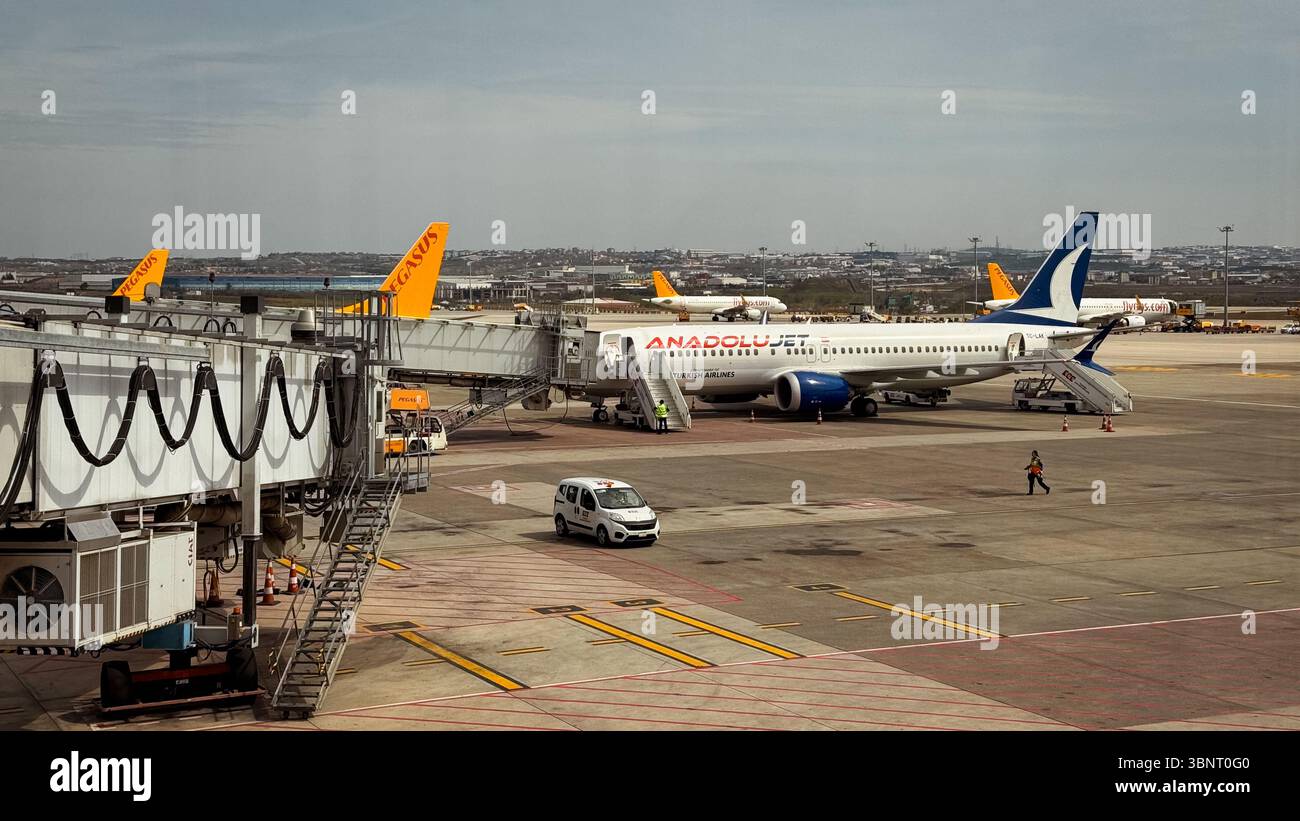 Zahlreiche Flugzeuge parken am Flughafen Istanbul, die Passagiere bereiten sich an klaren Tagen auf das Einsteigen im Terminal vor. Stockfoto