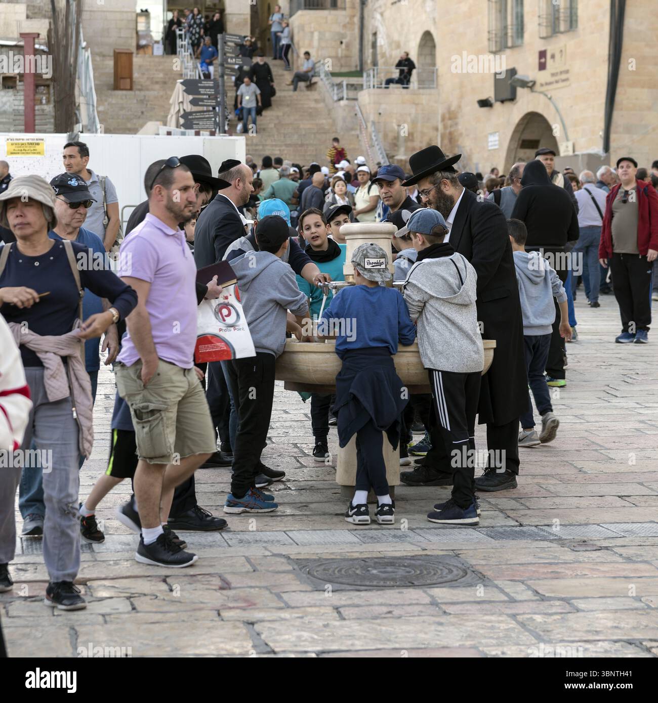 Israel Jerusalem Jüdische Jungen mit einem orthodoxen Lehrer am Handwaschbrunnen für Netilat Yadayim am Western Wall Plaza; rituelle Reinigung der Hände Stockfoto