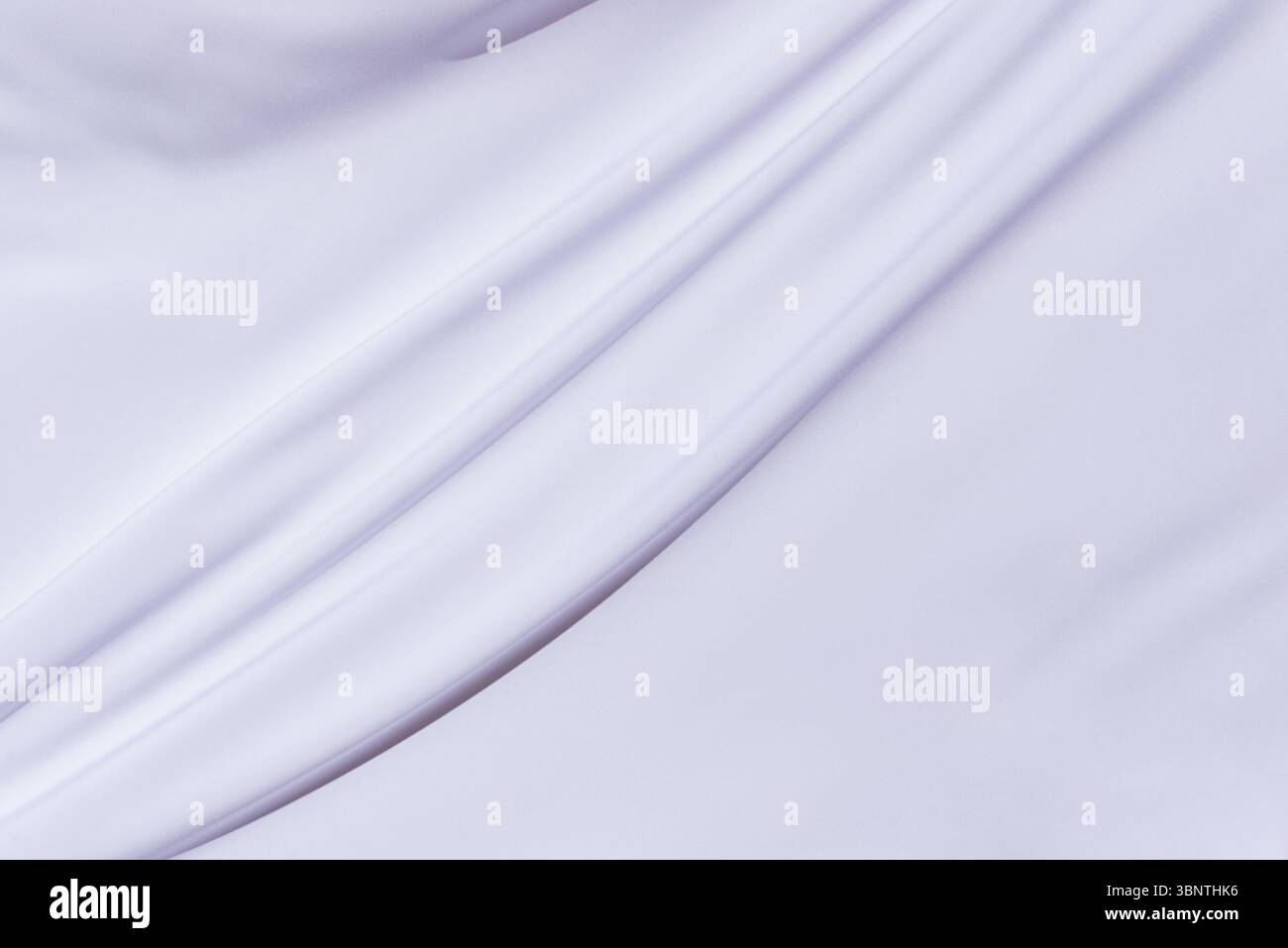 Nahaufnahme aus glattem weißem Gewebe mit diagonalen Falten, perfekt für Textil-Grafiken, Hintergrundkompositionen oder elegante Designschichten Stockfoto