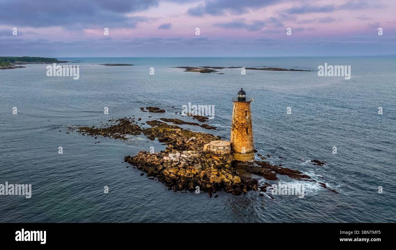 Whaleback Lighthouse ist ein einsamer Leuchtturm auf einem Felsvorsprung, umgeben von der Weite eines ruhigen Ozeans unter einem in Farbtönen gemalten Himmel Stockfoto