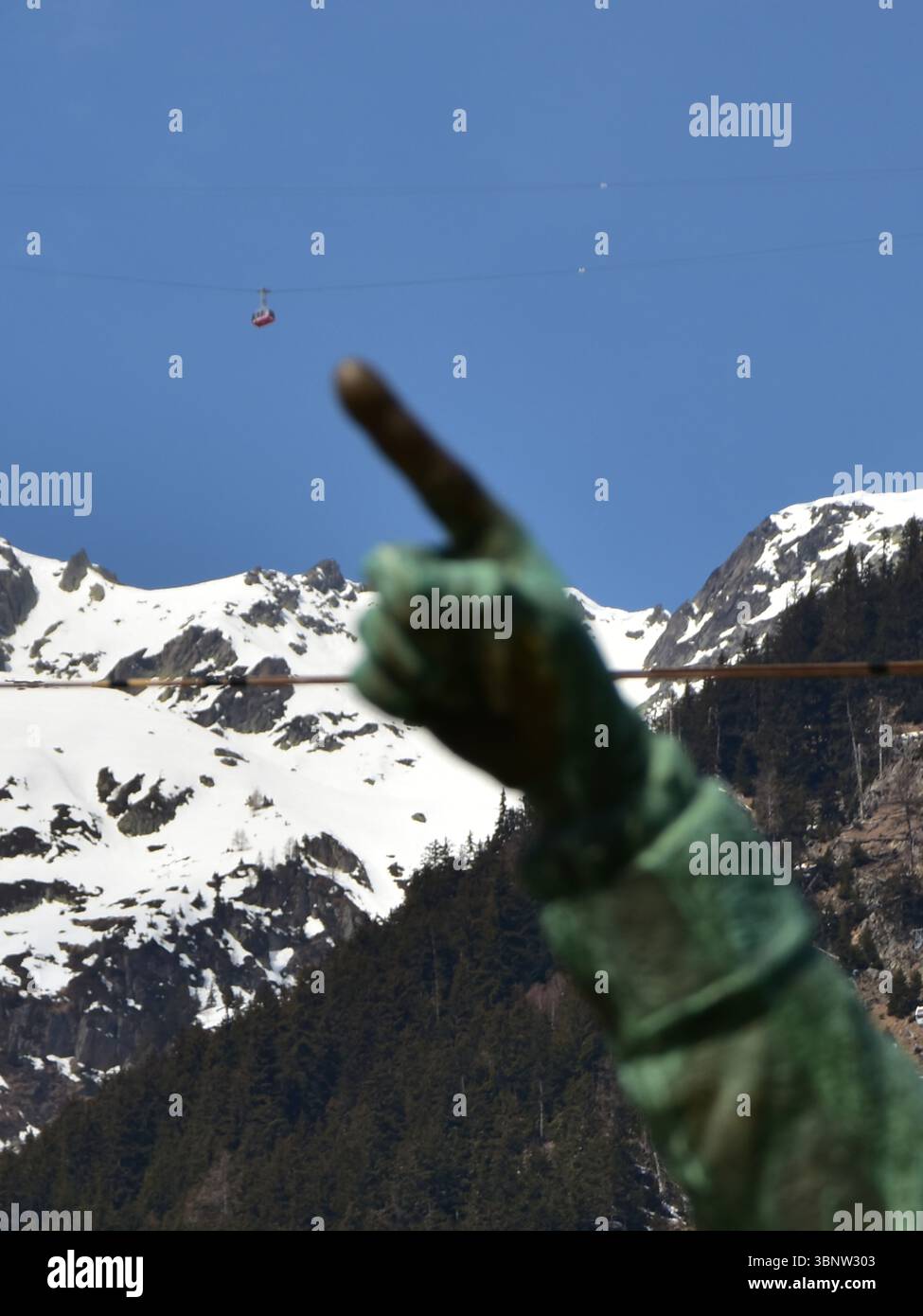 La statut de Jacques Balmat au Centre de Chamonix qui pointe le doigt sur l'une des Cabines du téléphérique du Brévent Stockfoto
