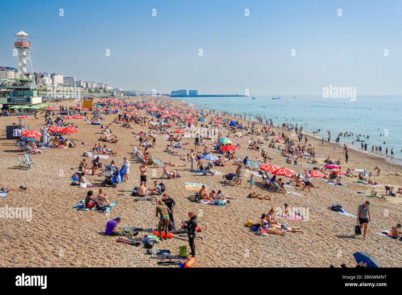 Menschen, die einen sonnigen Tag am Strand in Brighton, East Sussex England Großbritannien genießen Stockfoto