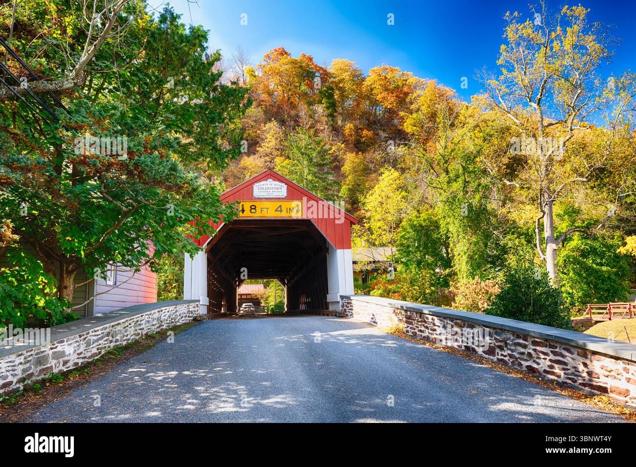 Niedrigwinkelansicht der Uhlerstown Covered Bridge während Peak Herbstlaub, Bucks County, Pennsylvania, USA Stockfoto