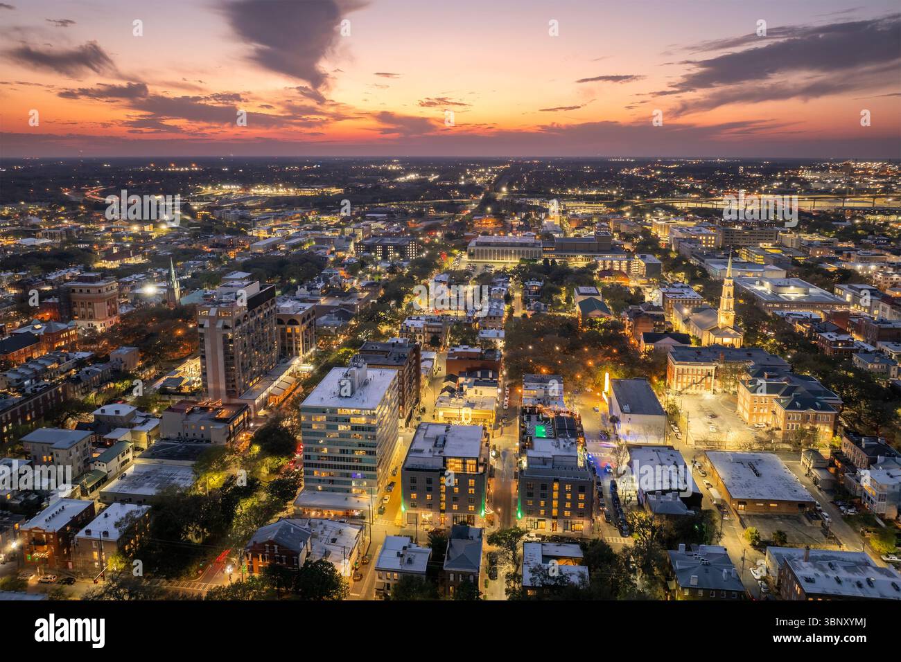 Alte historische Stadtarchitektur im Süden der USA. Blick von oben auf die beleuchteten Straßen von Savannah, Georgia bei Nacht Stockfoto