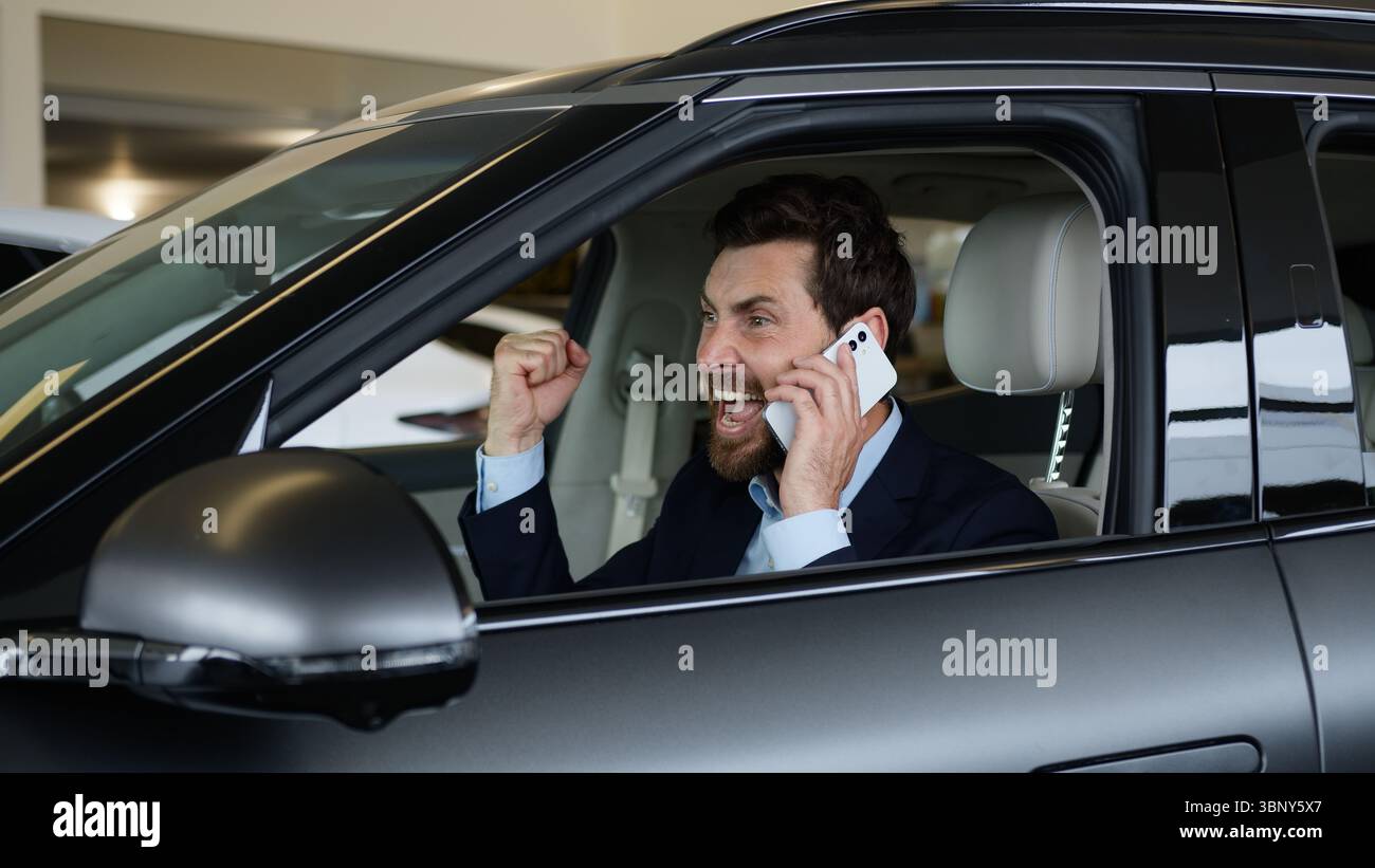 Glücklicher Kaukasischer Mann Kunde Käufer sprechendes Handy Smartphone neues Luxusauto männlicher Auto Auto Kauf Sieg Fahrer erreichen Geschäftsmann Stockfoto